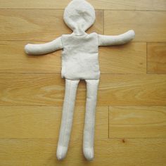 a white stuffed animal laying on top of a wooden floor