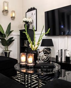 a black and white living room with candles on the coffee table in front of it