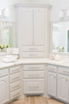 a bathroom with white cabinets and tile flooring