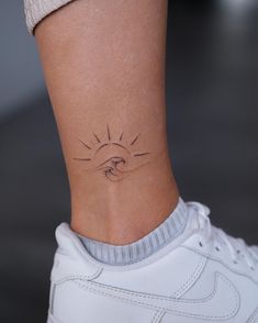 a woman's foot with a small tattoo on the side of her left ankle