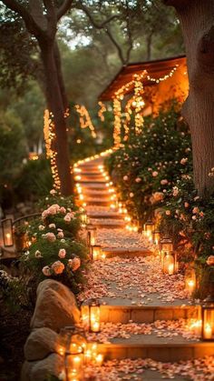 candles are lit on the steps leading up to a house with flowers and greenery