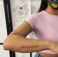 a woman with a tattoo on her arm that says, love is feminion