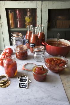 the table is covered with jars and containers of sauces, tomatoes, and other condiments