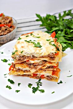 a stack of lasagna stacked on top of each other with meat and cheese