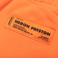 the label on an orange shirt that says heron reston