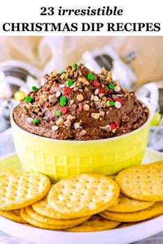 a bowl filled with chocolate dip surrounded by crackers and grahams on a plate