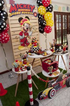 a mickey mouse birthday party with balloons and decorations