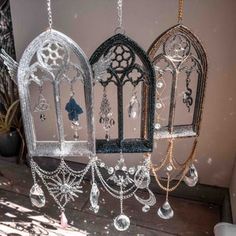 three birdcages are hanging from chains with crystal beads and jewels attached to them