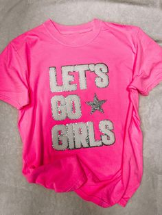 You'll love the fun and fashionable style of this LET'S GO GIRLS Chenille Comfort Colors T-Shirt! The pink color and chenille make it super cute, and the Comfort Colors fabric is soft and comfortable. Let's go girls! Unisex sizing and fit Pink Fun Top With Text Print, Pink Glitter Print Top For Summer, Pink Glitter Print Tops For Spring, Casual Pink Tops With Glitter Print, Pink Casual Top With Glitter Print, Fun Pink T-shirt With Letter Print, Pink Glitter Print Crew Neck Top, Casual Pink T-shirt With Glitter Print, Pink Cotton T-shirt With Glitter Print