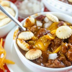 a white bowl filled with chili and dumplings on top of a red table cloth