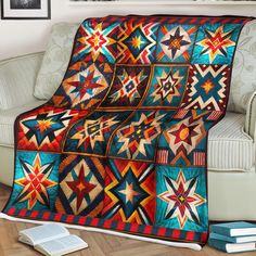 a couch with a quilt on it and a book sitting next to the couch in front of it