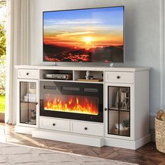 a flat screen tv sitting on top of a white entertainment center next to a fire place