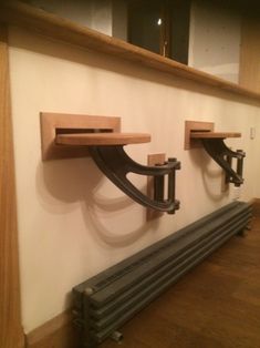 two wooden shelves mounted to the side of a wall with metal brackets on each shelf