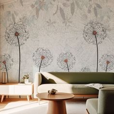 a living room with a couch, table and wallpaper on the walls that has dandelions painted on it