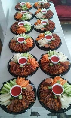 a table topped with black plates filled with different types of food and dipping sauces