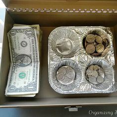 an open box filled with money sitting on top of a counter next to another container