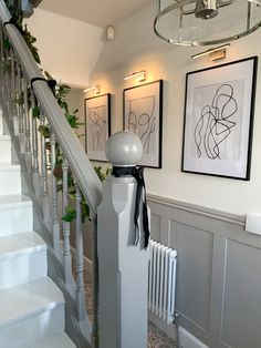 a staircase with pictures on the wall above it and a radiator next to it