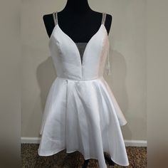 a white dress is displayed on a mannequin