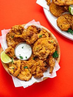 two plates filled with fried food on top of a red table