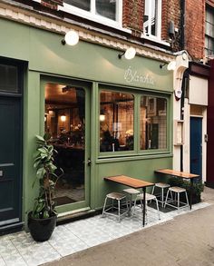 the outside of a restaurant with tables and chairs