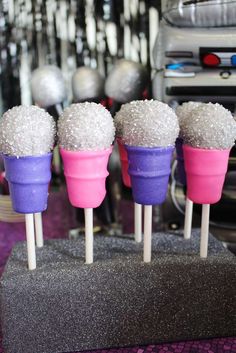 four ice cream cones with sprinkles on them sitting on top of a table