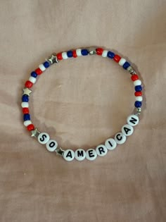 A hand-crafted glass bead friendship bracelet highlighting Olivia Rodrigo's song "So American"! A simple and cute way to show off your favorite song or a great concert accessory!  This bracelet is made with Czech glass beads, plastic letter beads, plastic spacer beads, and is on an elastic thread measured at about 10 inches in length for a relaxed/loose fit. If you would like the bracelet you order to be smaller or larger, please leave the requested size in inches in the personalization box!  Al Song Lyric Bracelet, All American B Olivia Rodrigo, Olivia Rodrigo Friendship Bracelet, Olivia Rodrigo Bracelets, Olivia Rodrigo Bracelet Ideas, Olivia Rodrigo Bracelet, Concert Bracelets, Bead Friendship Bracelet, Music Bracelet