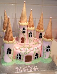 a cake shaped like a pink castle with towers