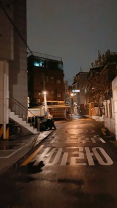 an empty city street at night with no one on the sidewalk or in the distance