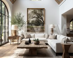 a living room with white couches and wooden tables in front of two large windows