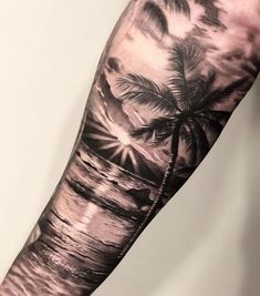 a man's arm with a palm tree on the beach