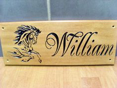 a wooden sign that says william with a horse and the word william written in cursive writing