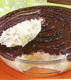 a chocolate cake with white frosting in a glass bowl