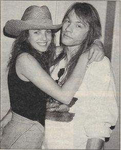 an old black and white photo of two women hugging each other, one wearing a cowboy hat