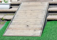 a wooden ramp sitting on top of green grass