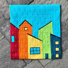 a colorful quilt with houses painted on it