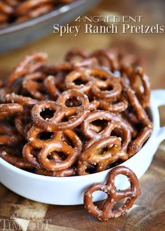 a bowl filled with pretzels sitting on top of a wooden table