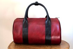 "All leather cylinder shaped duffel bag with long shoulder strap. Perfect as a small travel bag, hand luggage or casual gym duffel. Made from the finest italian leather outside and inside both. Item details: - The finest italian leather - Full-grain leather linning - Two internal side pockets - Attached handle cuff to hold both handles together - Adjustable cross-body strap - YKK zippers and solid brass hardware. - Hidden loops for a shoulder strap - Designed and produced by own small manufactur Functional Red Leather Bag, Red Leather Travel Duffle Bag, Red Leather Duffle Bag For Travel, Red Leather Duffle Bag For Everyday, Red Leather Luxury Travel Bag, Luxury Red Leather Travel Bag, Red Leather Travel Bag For Everyday Use, Small Travel Bag, Leather Duffel