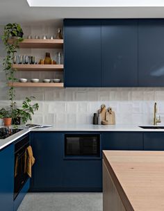 a kitchen with blue cabinets and wooden counters