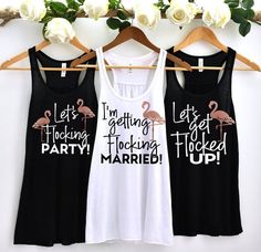 three women's tank tops with flamingos printed on them hanging from a rack