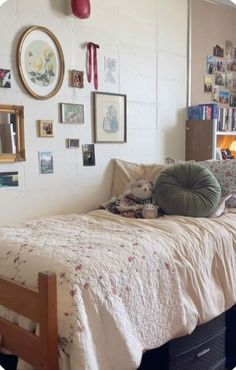 a bedroom with a bed, pillows and pictures on the wall