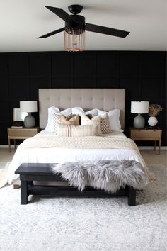 a bedroom with black walls and white bedding