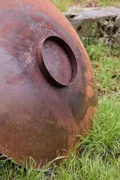 an old rusted metal object sitting in the grass