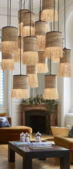 a living room filled with lots of light fixtures hanging from it's ceiling above a fire place