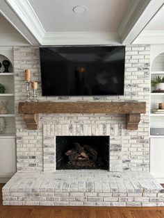 a fireplace with a flat screen tv mounted above it's mantle in a living room