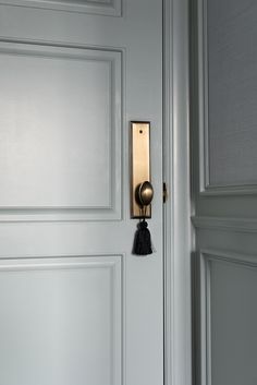 a door handle with a tassel hanging from it's side and on the wall