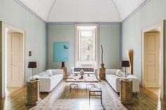 a living room filled with white couches and wooden floors