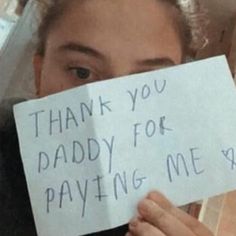 a woman holding up a sign that says thank you daddy for paying me $ 10