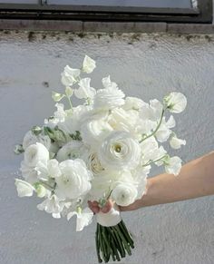 a person holding a bouquet of white flowers