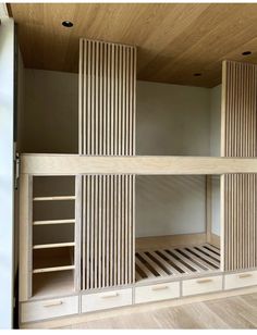 a bunk bed built into the side of a wall with wooden slats on it