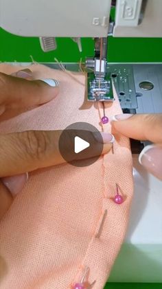 someone is using a sewing machine to sew something on a pink cloth with beads